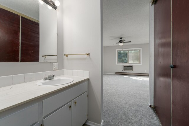 bathroom featuring vanity, an AC wall unit, ceiling fan, a textured ceiling, and baseboard heating