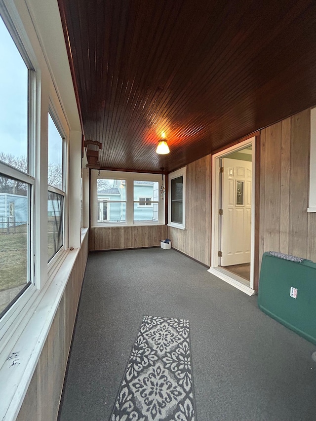 unfurnished sunroom with wood ceiling