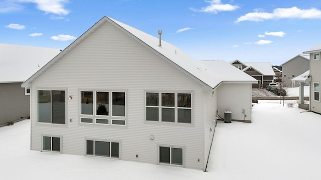 snow covered back of property featuring cooling unit