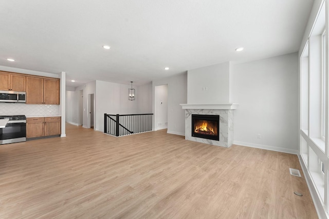 unfurnished living room with a fireplace and light hardwood / wood-style floors