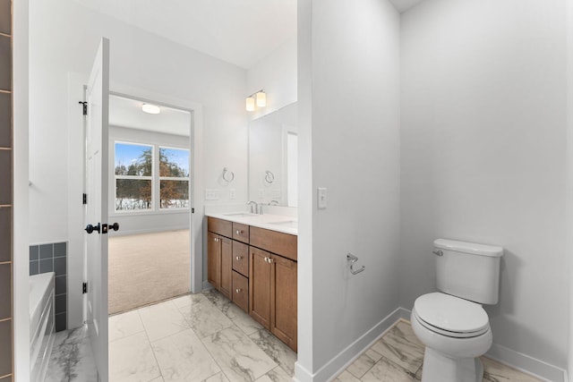 bathroom with vanity, a washtub, and toilet