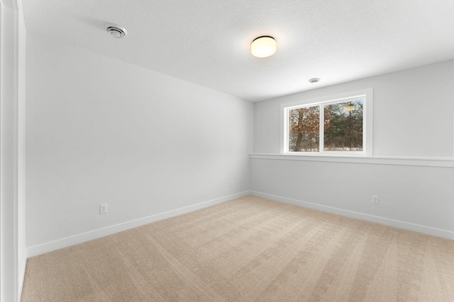 carpeted spare room with a textured ceiling