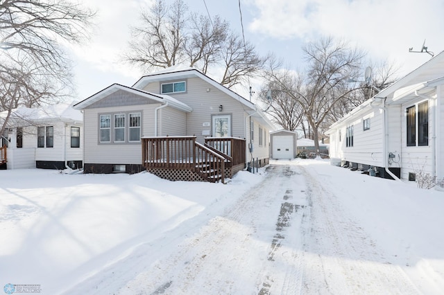 snow covered back of property with a deck