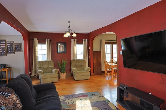 living room with an inviting chandelier and light wood-type flooring