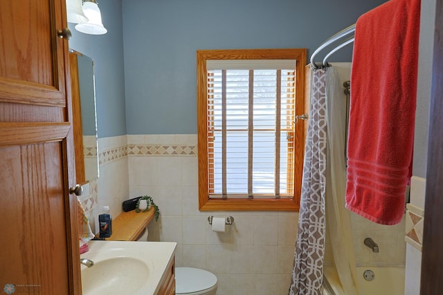 full bathroom featuring vanity, toilet, shower / bath combo with shower curtain, and tile walls