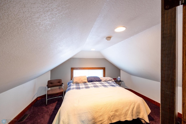 bedroom with vaulted ceiling, a textured ceiling, and carpet flooring