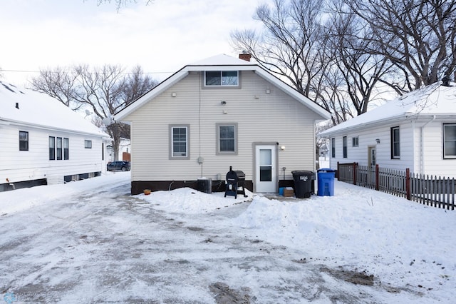 snow covered house featuring central AC