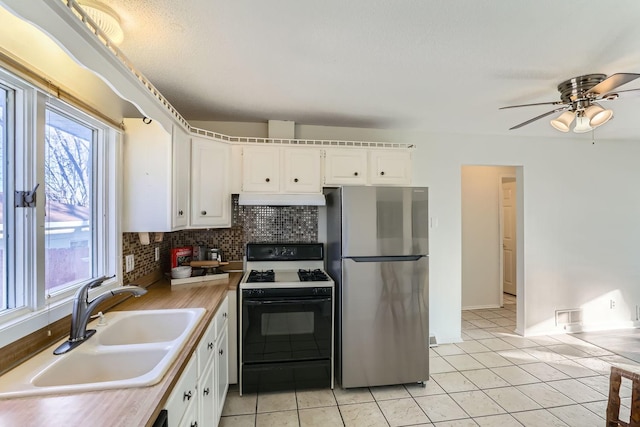 kitchen with sink, stainless steel fridge, white range with gas cooktop, decorative backsplash, and white cabinets