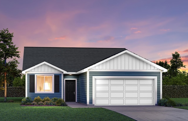 view of front of home with a garage and a yard