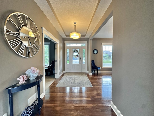 foyer entrance with dark hardwood / wood-style floors and a textured ceiling