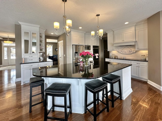 kitchen with stainless steel fridge with ice dispenser, white cabinets, a center island, and a chandelier