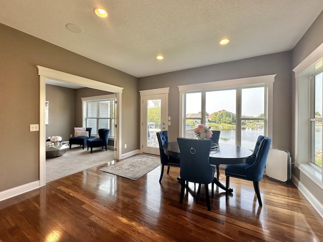 dining space with hardwood / wood-style floors and a textured ceiling