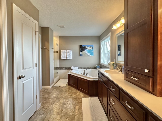 bathroom with vanity, separate shower and tub, and a textured ceiling