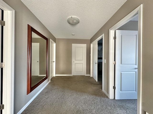 hallway featuring a textured ceiling and carpet flooring