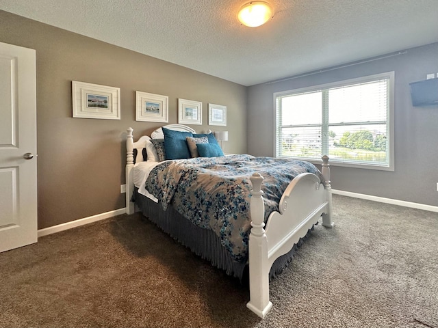 bedroom with a textured ceiling and dark colored carpet