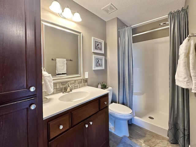 bathroom featuring vanity, toilet, a shower with shower curtain, and a textured ceiling