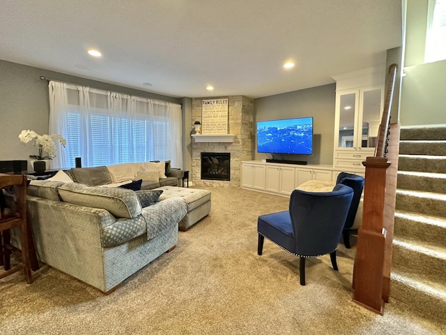 living room featuring a large fireplace and light carpet