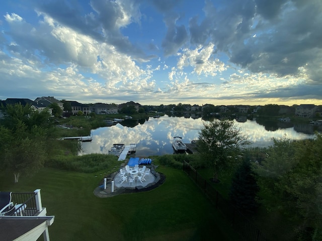 aerial view at dusk featuring a water view