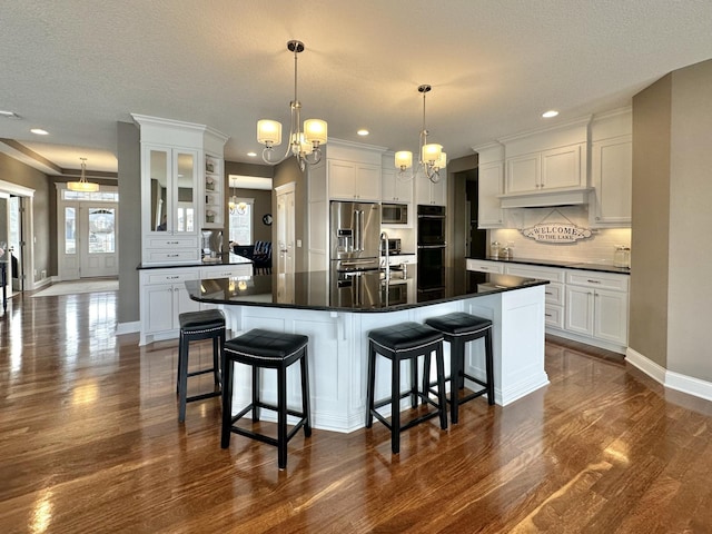 kitchen with dark countertops, white cabinetry, appliances with stainless steel finishes, and tasteful backsplash