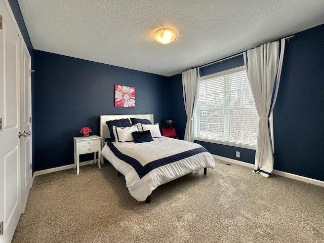 carpeted bedroom with visible vents, a textured ceiling, and baseboards