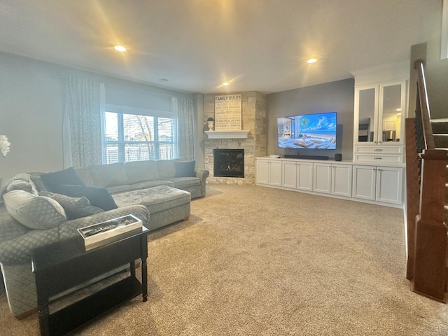 living room featuring recessed lighting, light colored carpet, and a fireplace