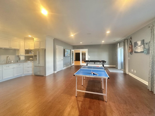 rec room featuring dark wood-style floors, baseboards, a sink, and recessed lighting