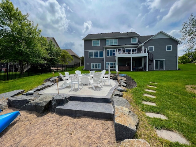 rear view of house with a deck, fence, a yard, stairway, and a patio area