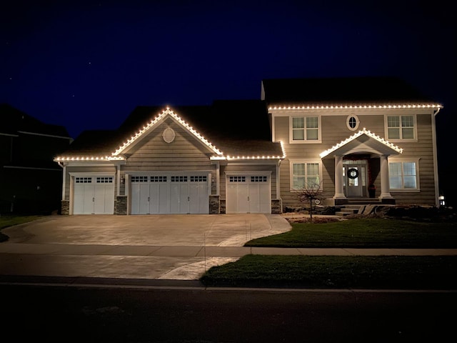 view of front of home with a garage, stone siding, and concrete driveway