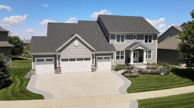 colonial-style house featuring stone siding, a shingled roof, concrete driveway, and a front yard