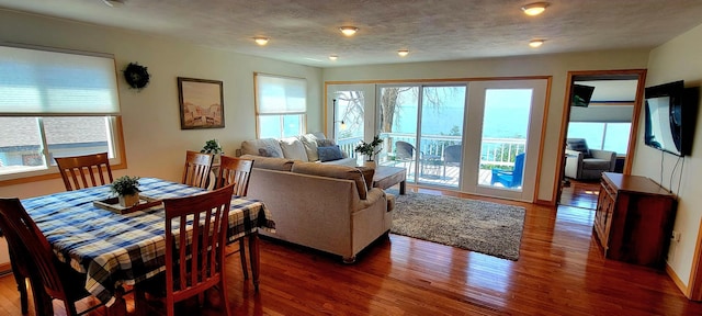 dining space with a textured ceiling and dark wood-type flooring