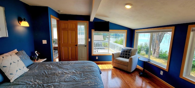 bedroom featuring lofted ceiling with beams and wood-type flooring