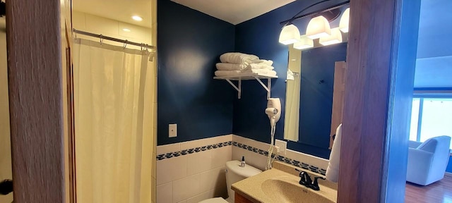 bathroom with vanity, a shower with curtain, toilet, tile walls, and wood-type flooring