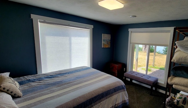 carpeted bedroom featuring access to exterior and a textured ceiling