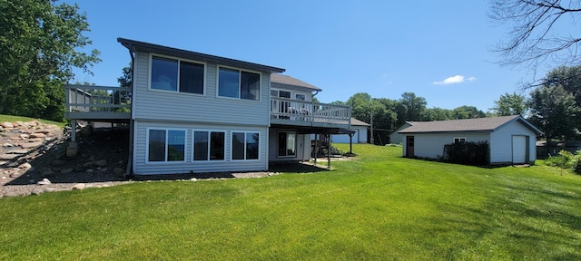 rear view of property featuring a yard, a deck, and an outdoor structure