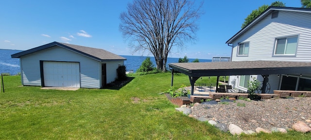 view of yard featuring a garage, an outdoor structure, and a water view