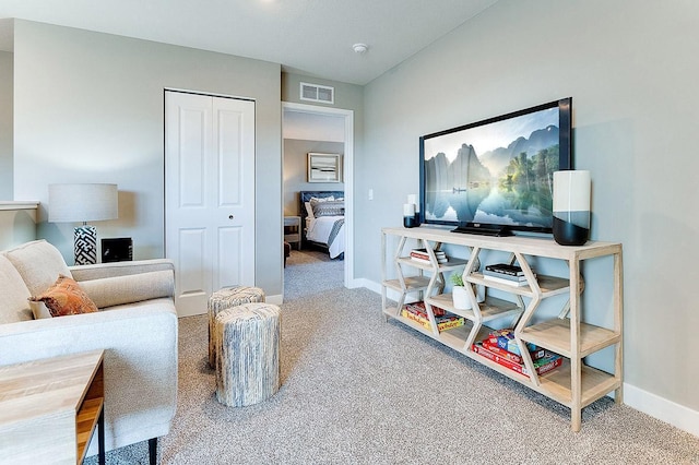 living area with baseboards, visible vents, and carpet flooring