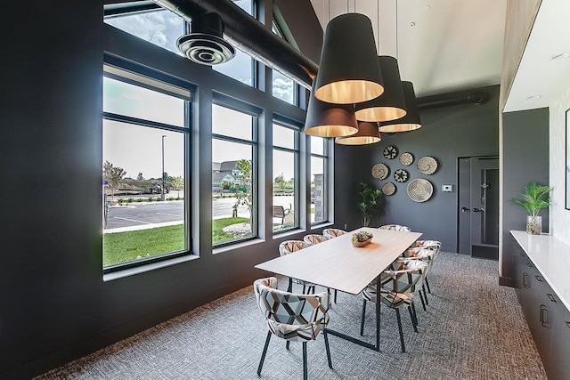 dining space featuring a towering ceiling