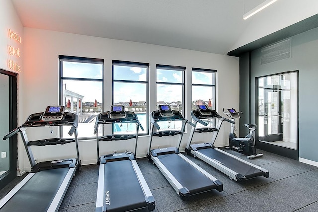 workout area featuring lofted ceiling and baseboards