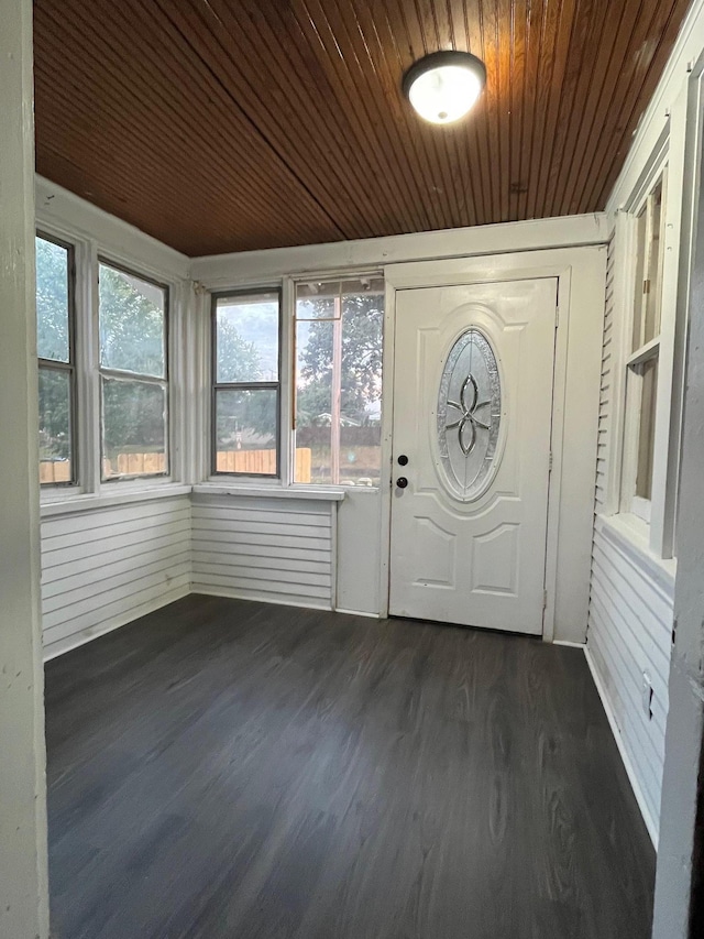 entryway with dark hardwood / wood-style floors, wooden ceiling, and wood walls