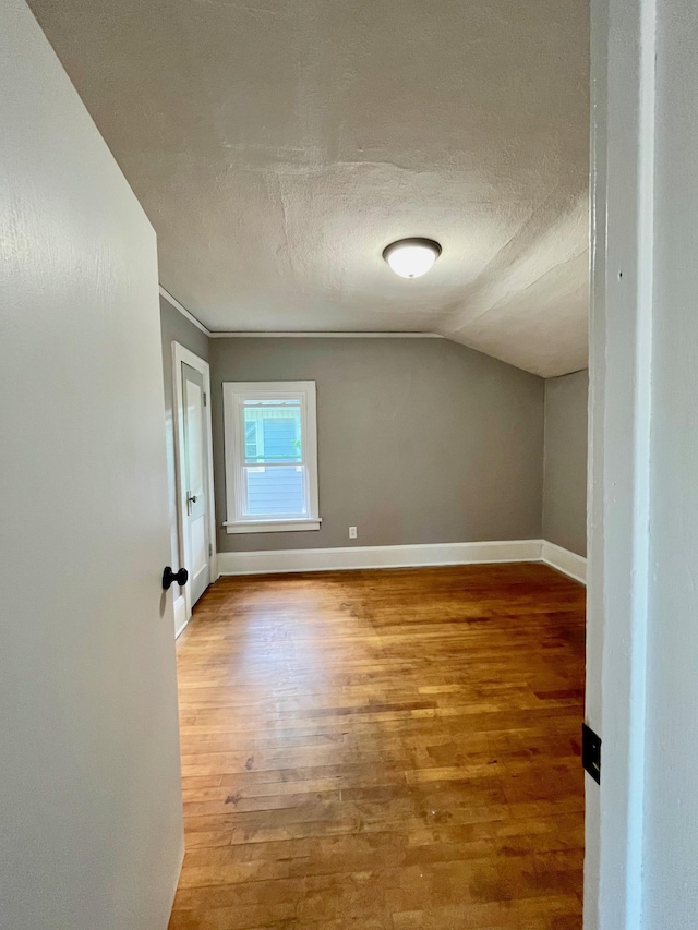 bonus room with a textured ceiling, hardwood / wood-style flooring, and lofted ceiling