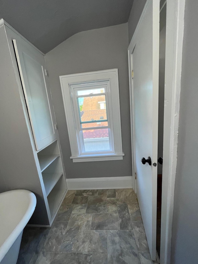 bathroom featuring vaulted ceiling and a bathing tub