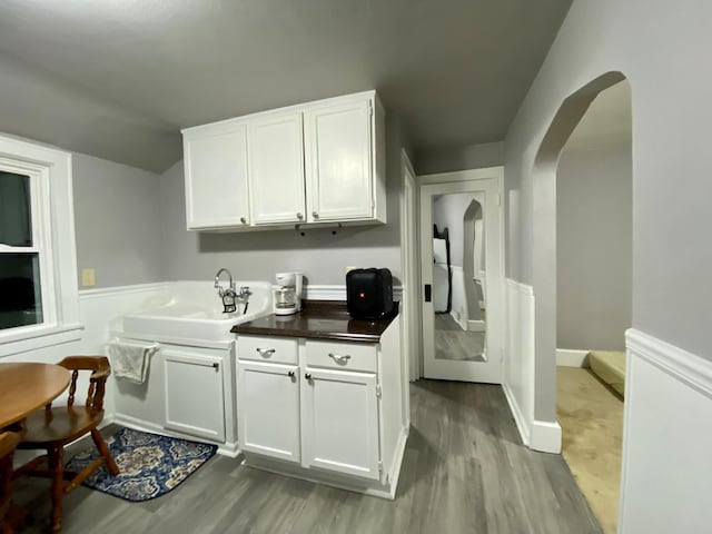 interior space with light hardwood / wood-style floors, white cabinetry, and sink