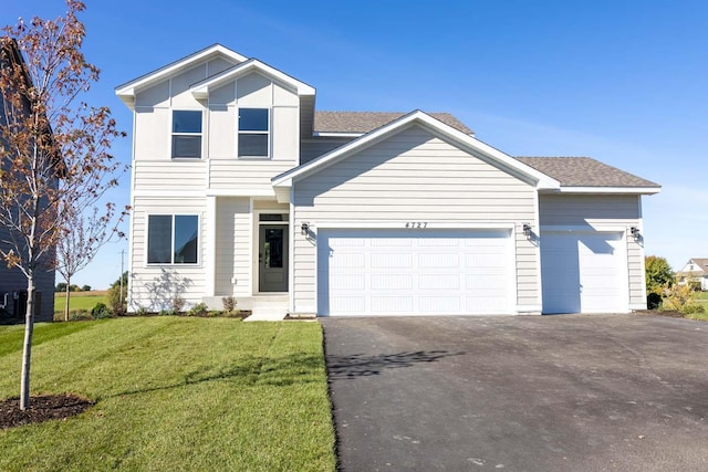 view of front of home with a front yard and a garage