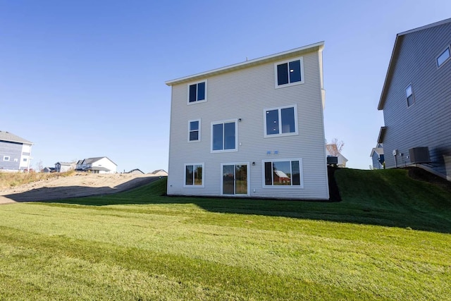 rear view of property featuring a yard and central AC unit