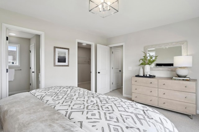 carpeted bedroom with a spacious closet and a closet