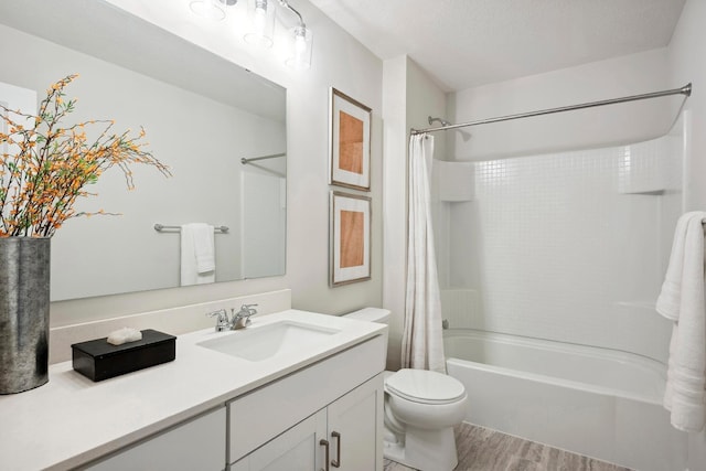 full bathroom with shower / bath combo, hardwood / wood-style floors, a textured ceiling, toilet, and vanity