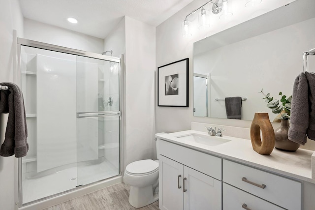 bathroom with hardwood / wood-style flooring, vanity, and walk in shower