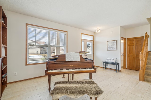 living area with baseboards and stairs