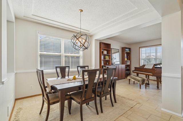 dining area featuring wood finish floors, baseboards, a textured ceiling, and an inviting chandelier