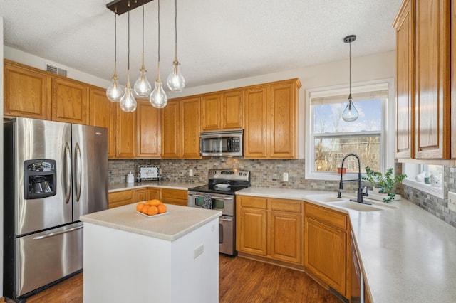 kitchen with visible vents, a sink, dark wood finished floors, appliances with stainless steel finishes, and light countertops